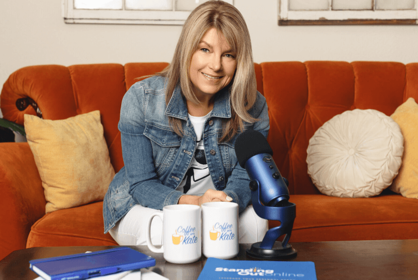 Woman podcasting with blue mic on orange sofa.